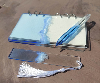Set da cancelleria in resina artigianale a tema mare con effetto onde blu e schiuma bianca, composto da un taccuino con anelli metallici, una penna e un segnalibro 