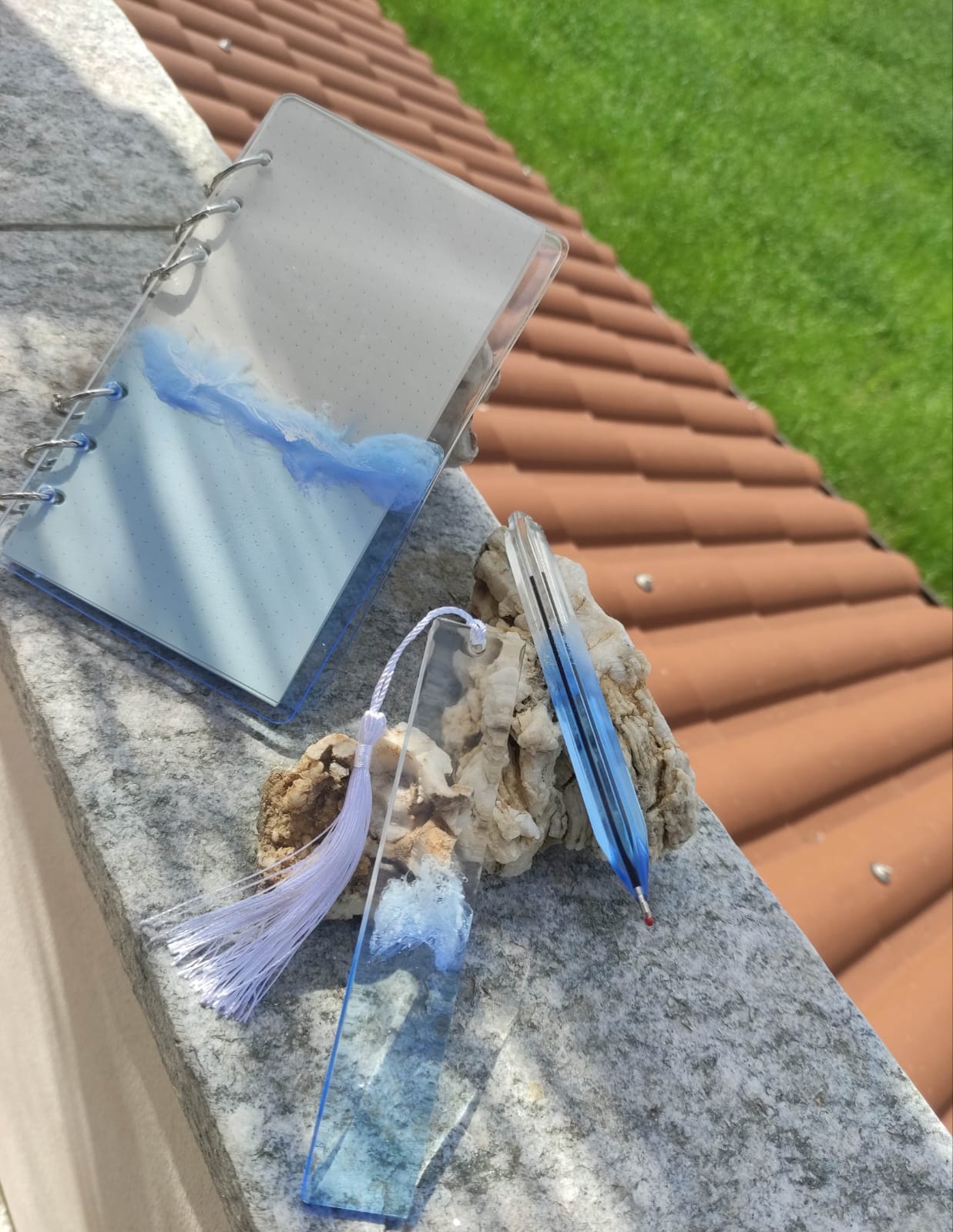 Set da cancelleria in resina artigianale a tema mare con effetto onde blu e schiuma bianca, composto da un taccuino con anelli metallici, una penna e un segnalibro 