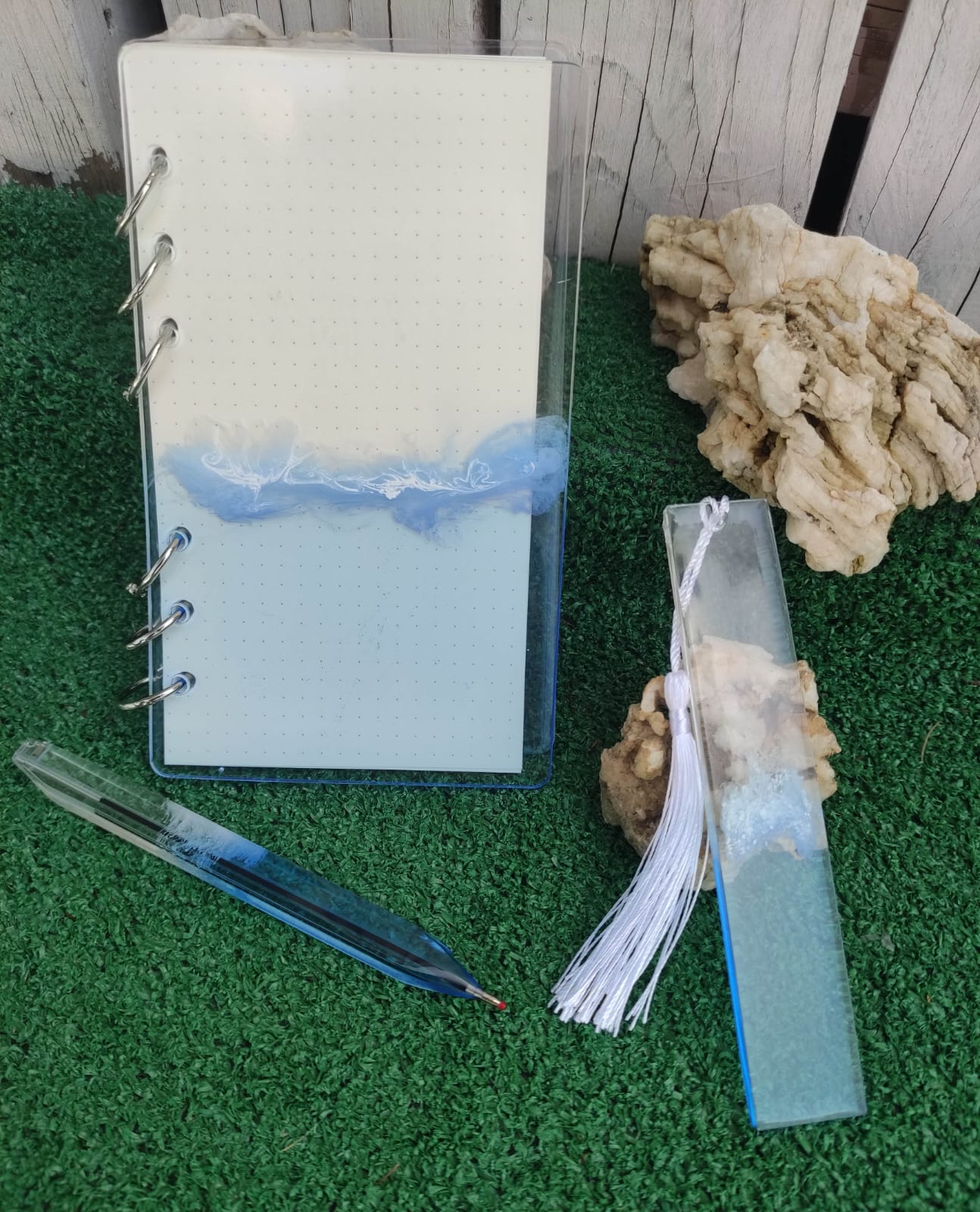 Set da cancelleria in resina artigianale a tema mare con effetto onde blu e schiuma bianca, composto da un taccuino con anelli metallici, una penna e un segnalibro 