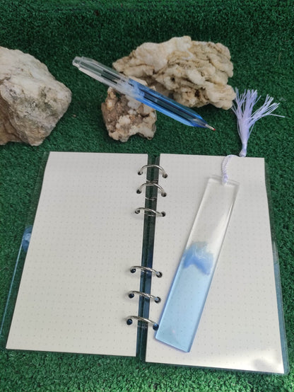 Set da cancelleria in resina artigianale a tema mare con effetto onde blu e schiuma bianca, composto da un taccuino con anelli metallici, una penna e un segnalibro 